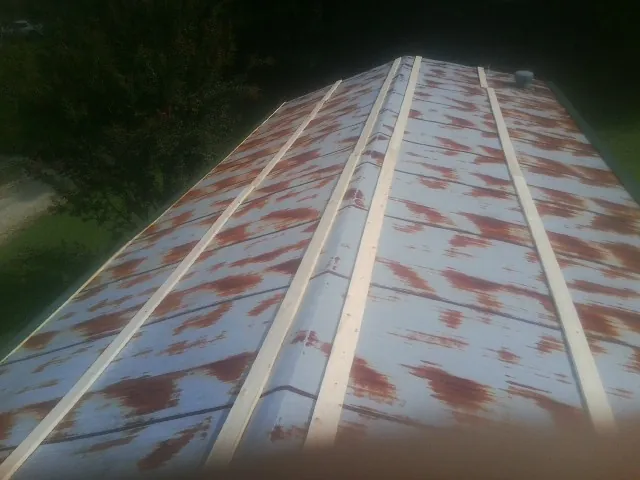 Rusted metal roof panels with new wood purlins before replacement — Storm Damage Roof Repair in Scappoose by Roofing Brothers
