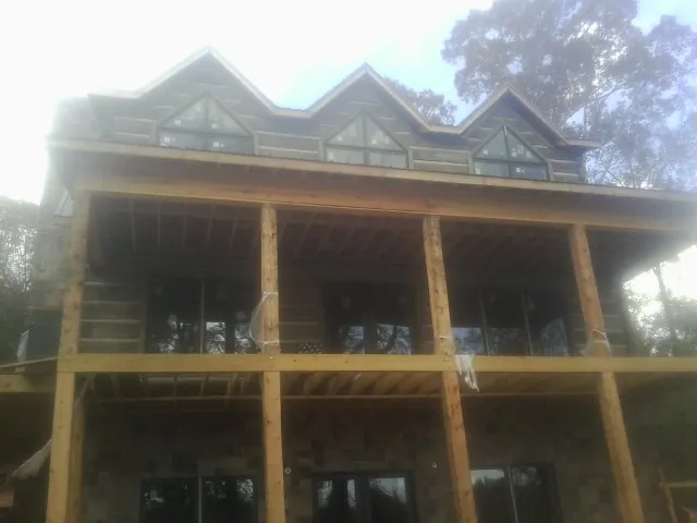 Dormers and porch framing on a large log home under construction — Roof Coating work by our crew in Scappoose