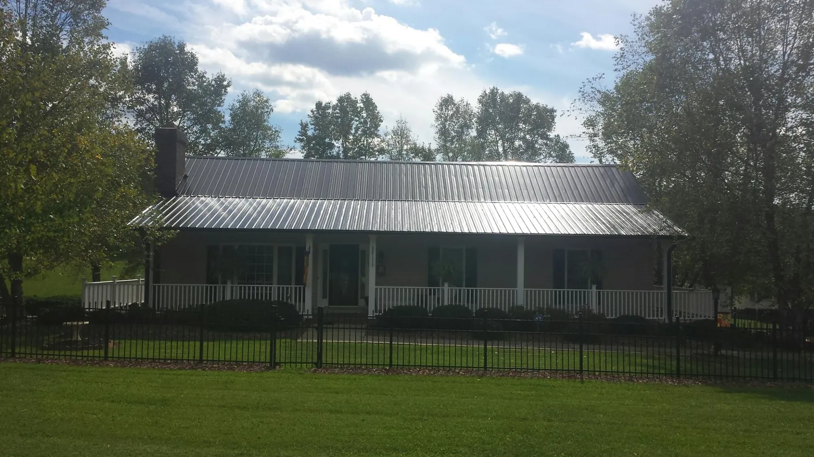 Gray metal roof on a brick ranch with a full width front porch — Gutter Guard Installation work by our crew in Scappoose