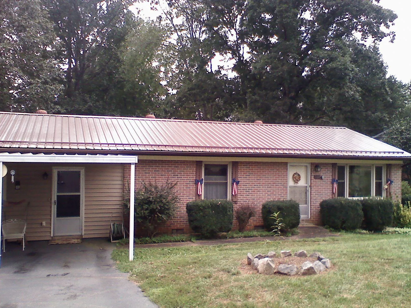 Bronze metal roof and carport on a brick ranch home — Roof Repair work by our crew in Scappoose